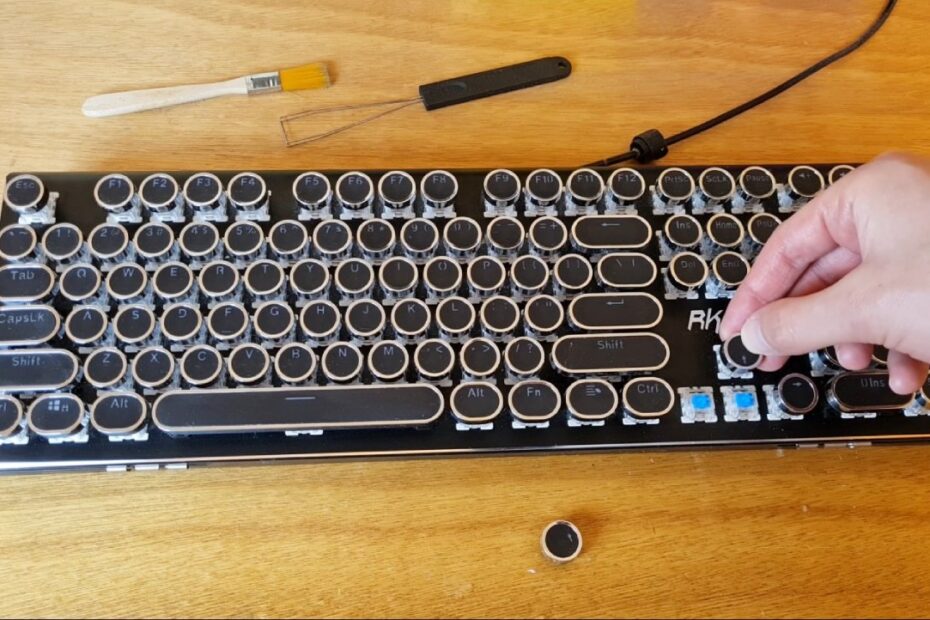 Cleaning a typewriter keyboard with a puller and brush on the side